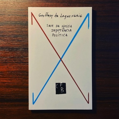 Livro branco com X vermelho e azul e texto manuscrito sobre mesa de madeira escura