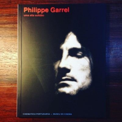 Capa preta de livro com foto em preto e branco de um rosto e texto vermelho e branco.