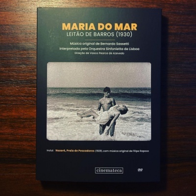 Capa de DVD preta com título amarelo e branco e fotografia a preto e branco de homem e mulher na praia.