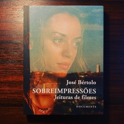 Capa do livro 'Sobreimpressões leituras de filmes' de José Bértolo com imagem de mulher e cidade ao fundo