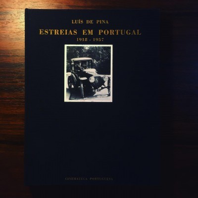 Livro preto de capa dura com texto dourado e fotografia a preto e branco de carro antigo na capa