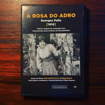 Capa de DVD do filme 'A Rosa do Adro' com imagem a preto e branco de uma mulher e texto em português