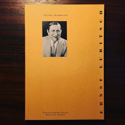 Livro amarelo com foto preto e branco de homem formalmente vestido e texto impresso