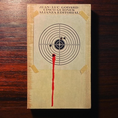 Capa de livro com alvo de tiro e texto de autoria e editora sobre madeira escura