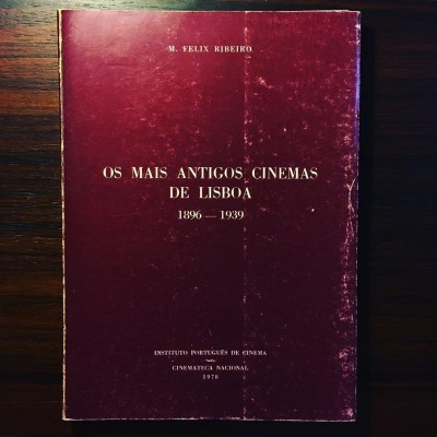 Livro antigo vermelho de capa dura sobre mesa de madeira