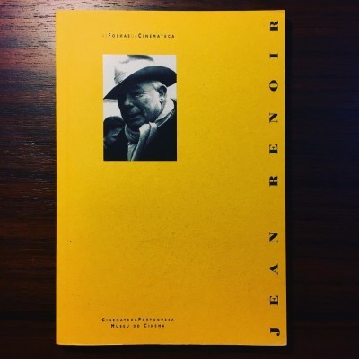 Capa de livro amarela com foto a preto e branco de homem de chapéu, texto sobre Jean Renoir.
