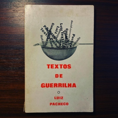 Capa de livro branco com texto vermelho e gráfico de chapéu preto sobre fundo de madeira escura