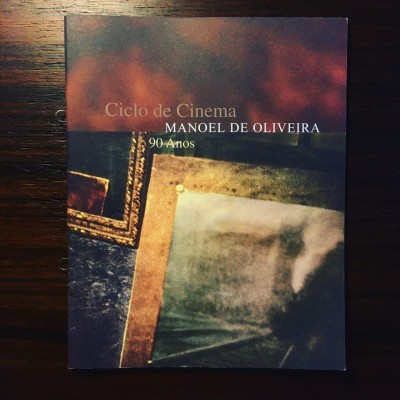 Capa de livro 'Ciclo de Cinema MANOEL DE OLIVEIRA 90 Anos' com montagem de molduras e imagem desfocada