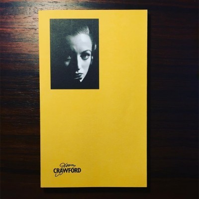 Livro amarelo com foto preto e branco e texto Joan Crawford