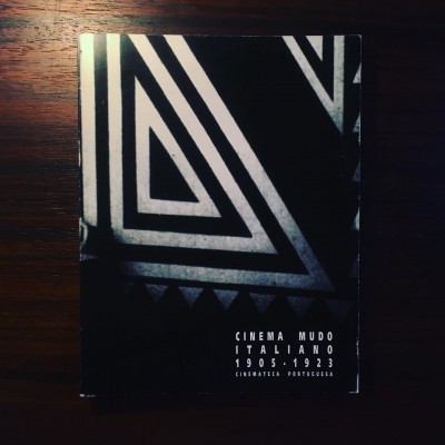 Livro 'Cinema Mudo Italiano 1905-1923' com capa preta e branca geométrica sobre mesa de madeira