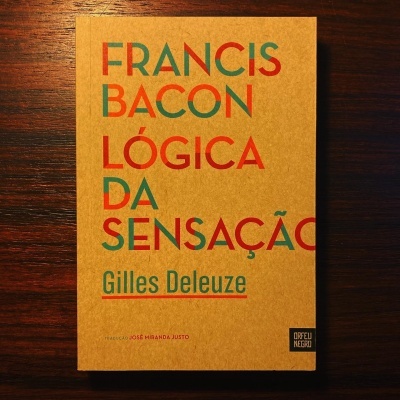 Capa de livro castanho claro com título colorido e autor em verde