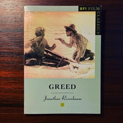 Capa de livro 'Greed' com imagem sépia de duas pessoas e texto 'BFI FILM CLASSICS'