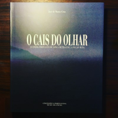 Capa de livro azul escura com título 'O CAIS DO OLHAR' em letras grandes brancas e subtítulo abaixo