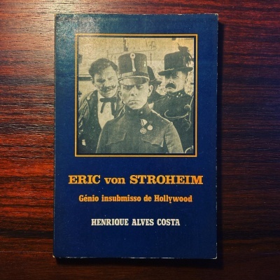 Capa de livro azul com foto preta e branca e texto em amarelo e branco