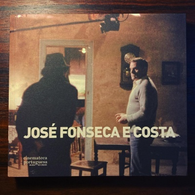 Capa com duas pessoas numa sala e texto JOSÉ FONSECA E COSTA