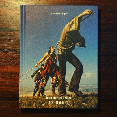 Livro com capa colorida mostrando pessoas com roupas tradicionais ao ar livre, com texto Jean-Paul Fargier, Jean-Daniel Pollet, LE SANG