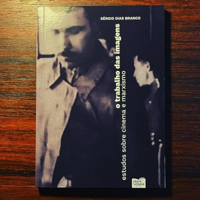 Livro com capa preta e fotografia desfocada, texto em branco e amarelo