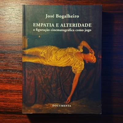 Capa de livro com figura humana de vestido amarelo deitada, título e autor em letras claras sobre fundo escuro