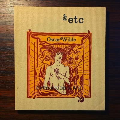 Livro em capa de tecido bege com ilustração laranja e texto de Oscar Wilde