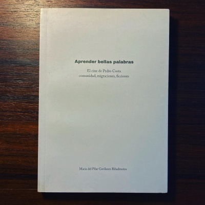 Livro branco com texto preto sobre superfície de madeira escura