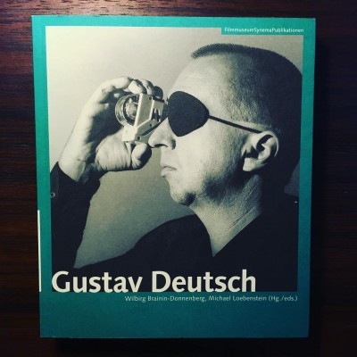 Capa de livro com fotografia a preto e branco de Gustav Deutsch com tapa-olho e objeto circular.
