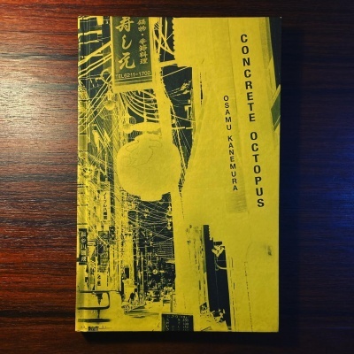 Capa do livro CONCRETE OCTOPUS sobre mesa de madeira