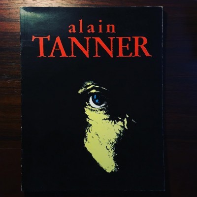Capa de livro preto com título alain TANNER e rosto parcialmente iluminado com olho azul