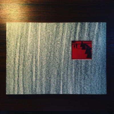 Caixa cinza com janela vermelha quadrada sobre mesa de madeira