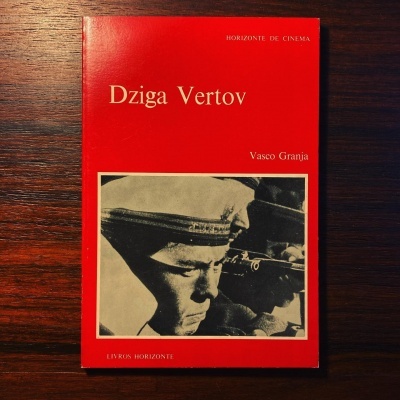 Capa de livro vermelha com título Dziga Vertov e foto em preto e branco de homem com boné militar