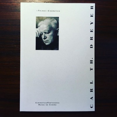 Capa branca de um livro com fotografia a preto e branco de um homem e texto em português e inglês.