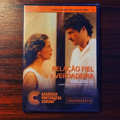 Caixa de DVD azul do filme RELAÇÃO FIEL E VERDADEIRA da coleção ACADEMIA PORTUGUESA DE CINEMA sobre fundo de madeira