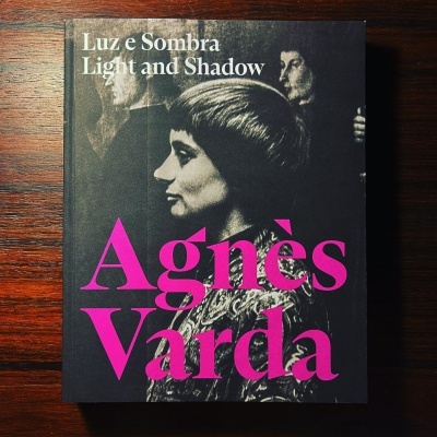 Capa de livro preto com texto e imagem em preto e branco e letras cor-de-rosa.