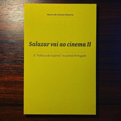 Livro capa amarela com texto preto sobre madeira