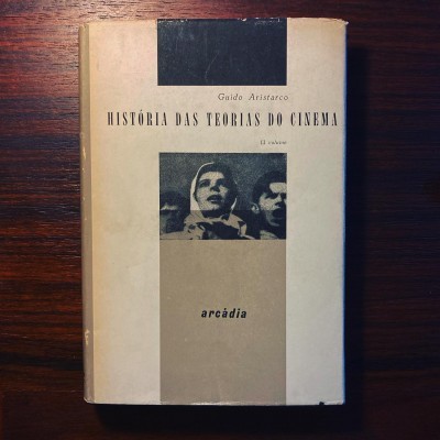 Capa de livro História das Teorias do Cinema de Guido Aristarco sobre mesa de madeira