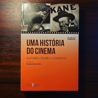 Capa do livro 'Uma História do Cinema' sobre uma superfície de madeira.