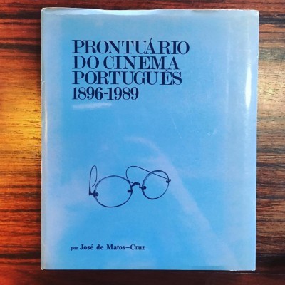 Livro PRONTUÁRIO DO CINEMA PORTUGUÊS 1896-1989 com capa azul e desenho de óculos