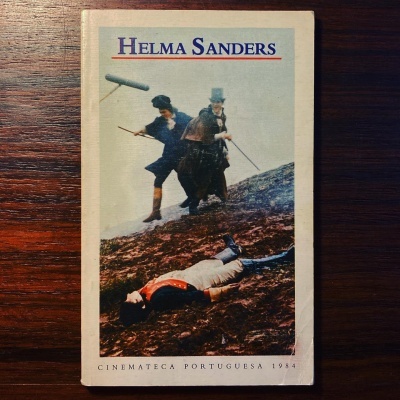 Capa de livro com título HELMA SANDERS e ilustração de três pessoas em cenário antigo