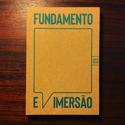 Livro Fundamento e Imersão com capa castanha clara e letras verdes azuis sobre madeira