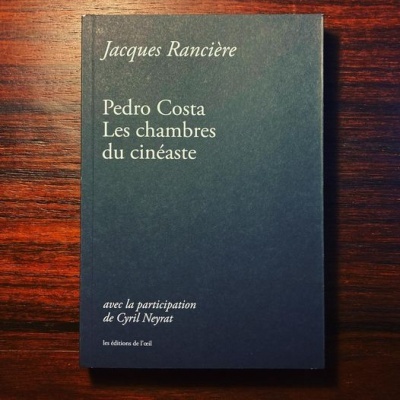 Livro preto com texto branco sobre superfície de madeira