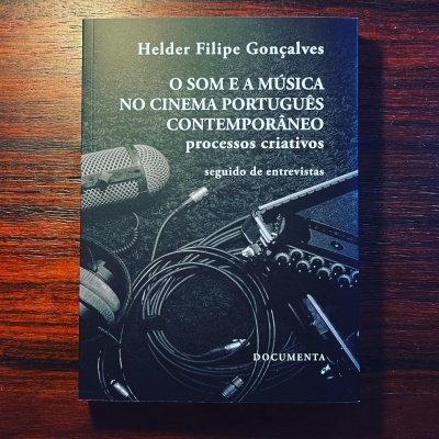 Livro com capa preta e imagem de microfone, cabos e equipamento de áudio