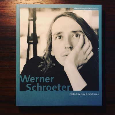 Capa azul de livro com fotografia a preto e branco de homem e texto Werner Schroeter