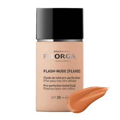 Fluido tintado Filorga Flash-Nude em embalagem com tampa preta e amostra do produto esbatido