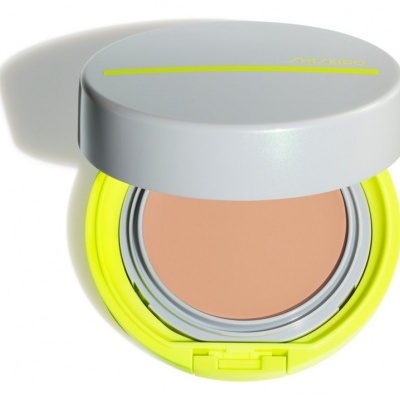 Compacto de maquilhagem bege claro com tampa cinza e base amarelo neon