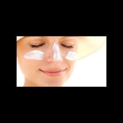 Mulher com creme aplicado no rosto e chapéu bege