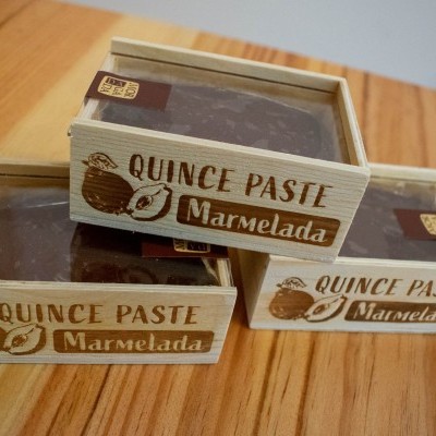 Caixas de madeira com pasta de marmelada castanha sobre uma superfície de madeira clara