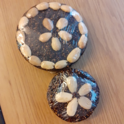 Dois biscoitos de chocolate decorados com amêndoas sobre superfície de madeira