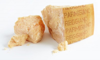 Pedaço de queijo Parmigiano Reggiano sobre fundo branco