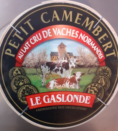 Embalagem redonda de queijo Petit Camembert com vacas e textos em dourado e vermelho.