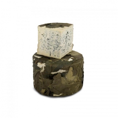 Queijo azul redondo coberto por folhas verdes com pedaço quadrado em cima