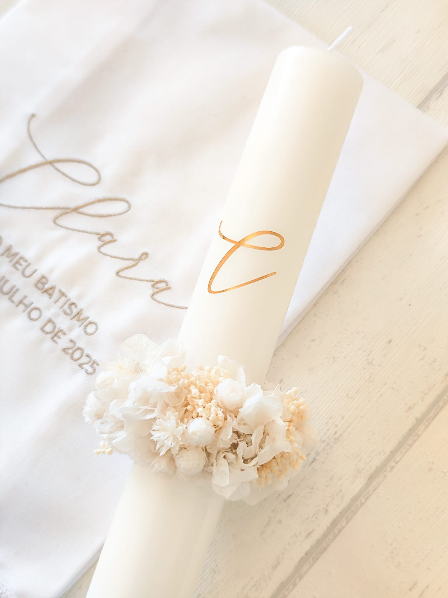 Vela branca alta decorada com flores e toalha bordada